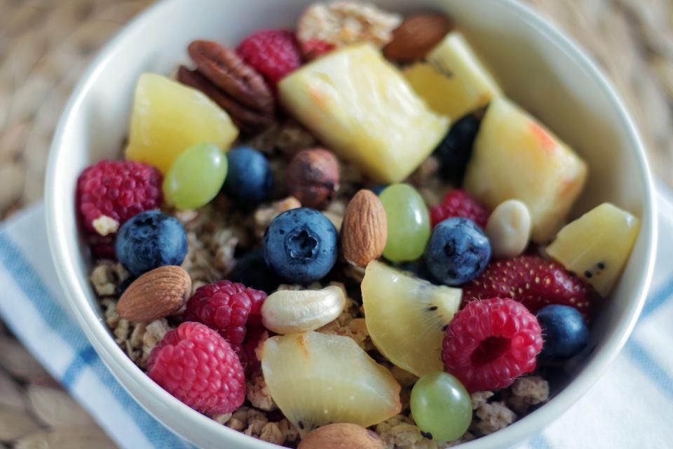 Ciotola di yogurt con frutti di bosco, frutta secca e semi